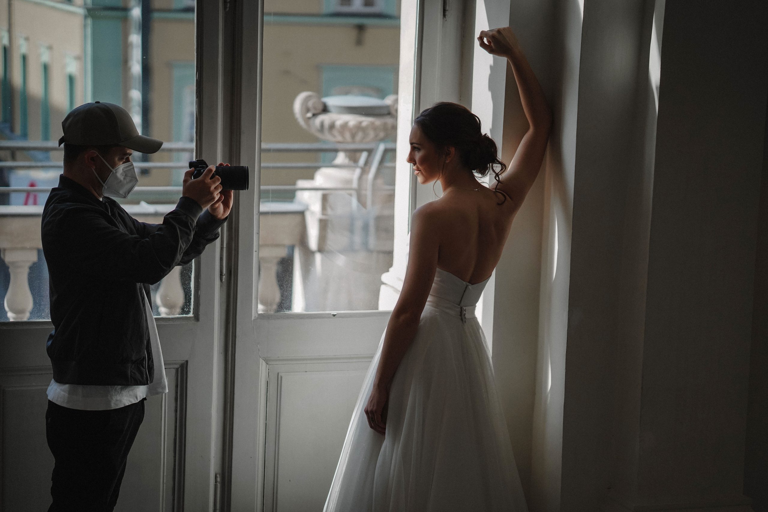 Zwei Personen spielen auf einem weiten, offenen Feld unter strahlend blauem Himmel Fangen. Einer balanciert zwei Bälle auf dem Kopf und fängt gleichzeitig einen dritten, während der andere, barfuß und mit Helm, bei jedem Wurf einer unvorhersehbaren Richtung folgt.